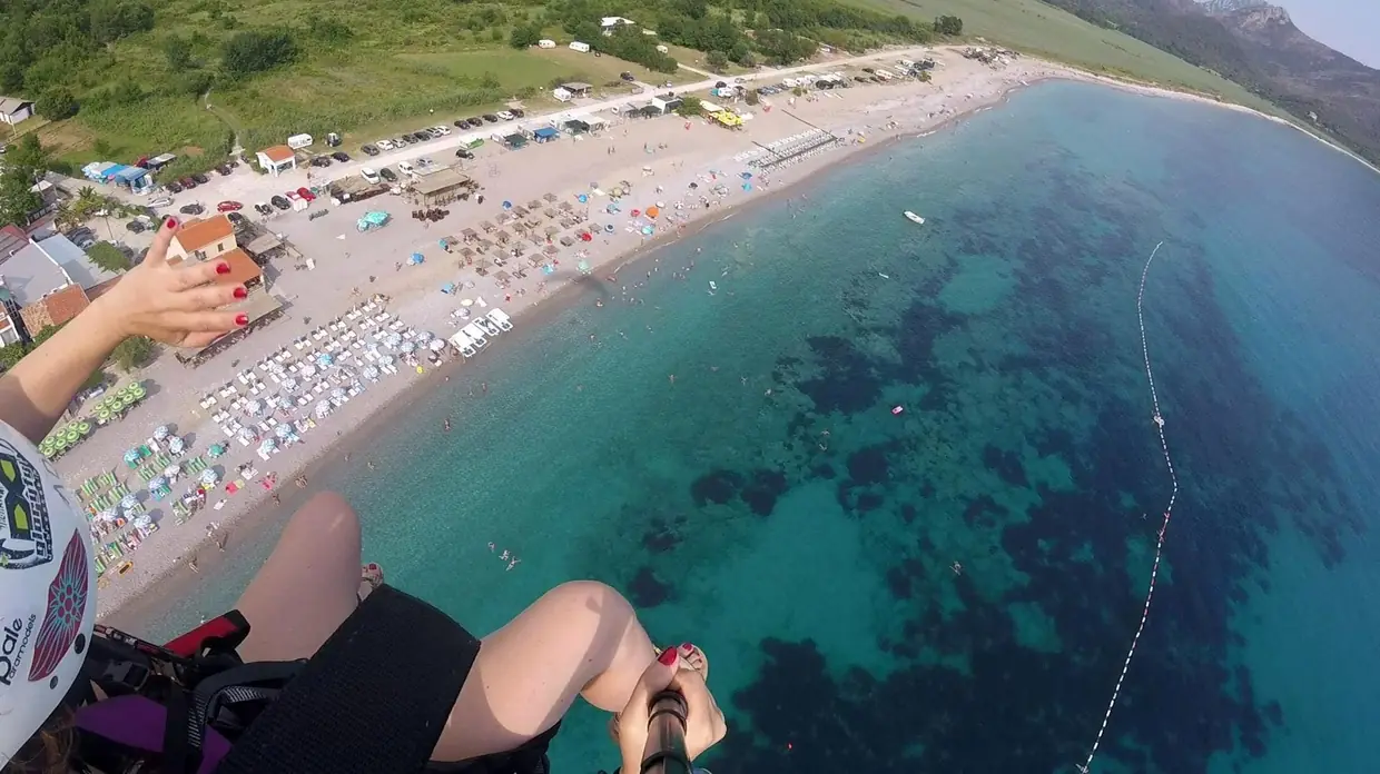 First-person coastal paragliding view over a Montenegro bay near the Camp base.